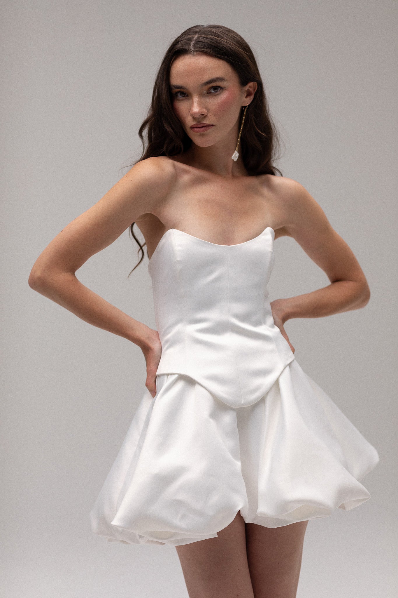 Detailed view of a satin mini bubble skirt, highlighting its playful silhouette and luxurious fabric, perfect for an unconventional bridal style