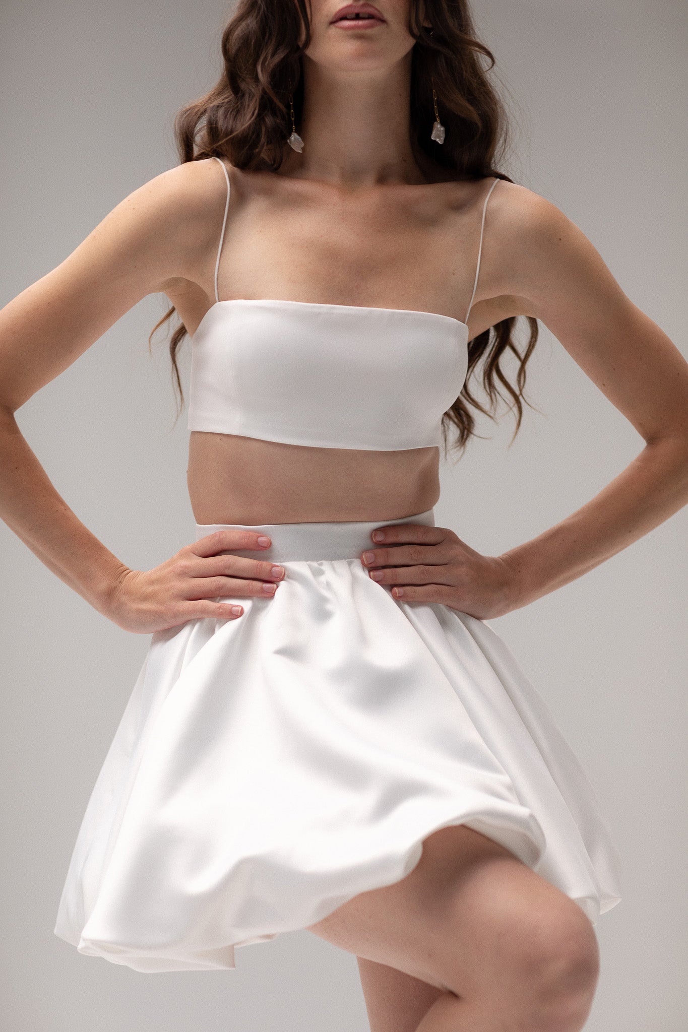 Detailed view of a satin mini bubble skirt, highlighting its playful silhouette and luxurious fabric, perfect for an unconventional bridal style