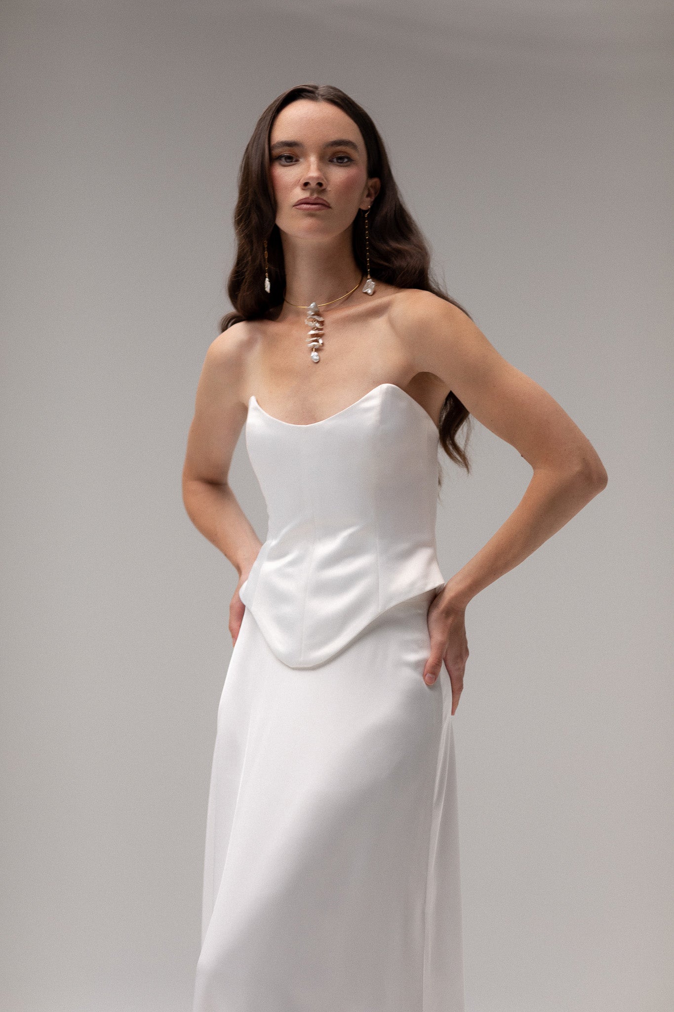 Model is wearing a satin corset top from TEMPÊTE, showcasing a sleek and tailored fit for a bold bridal outfit.