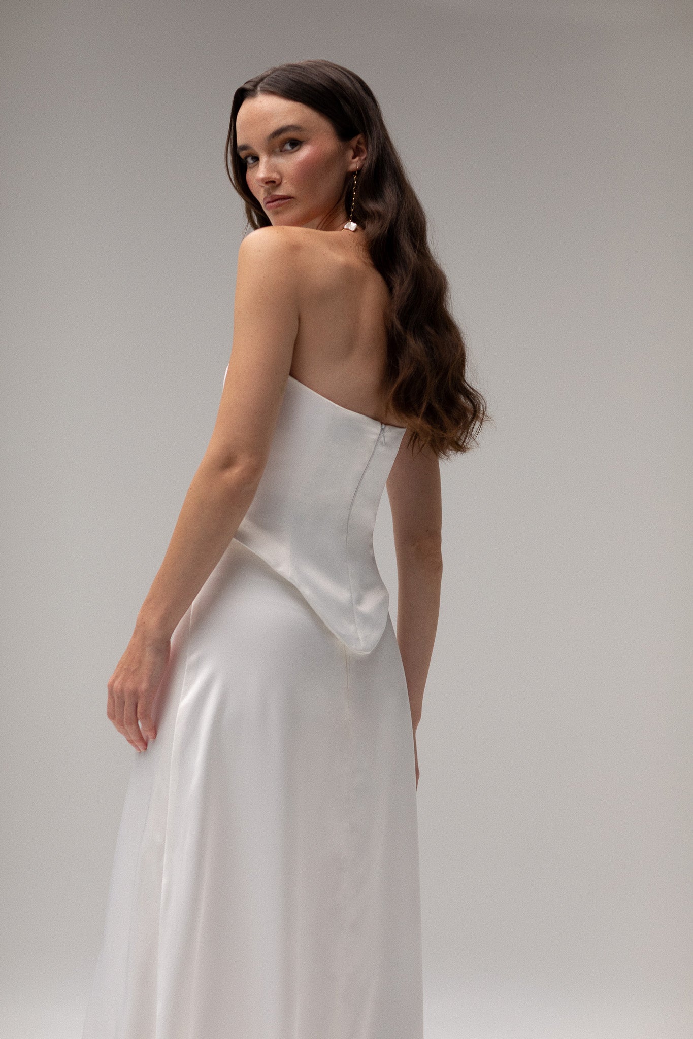 Model is wearing a satin corset top from TEMPÊTE, showcasing a sleek and tailored fit for a bold bridal outfit.