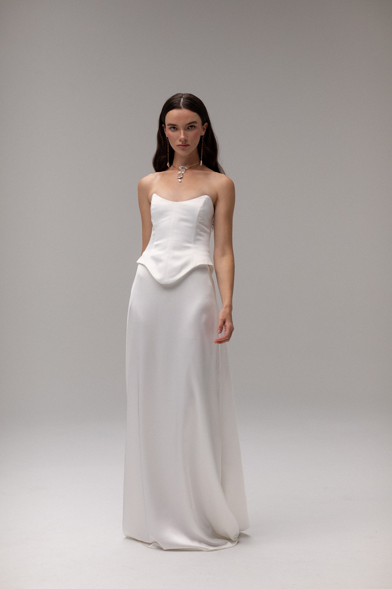 Model is wearing a satin corset top from TEMPÊTE, showcasing a sleek and tailored fit for a bold bridal outfit.