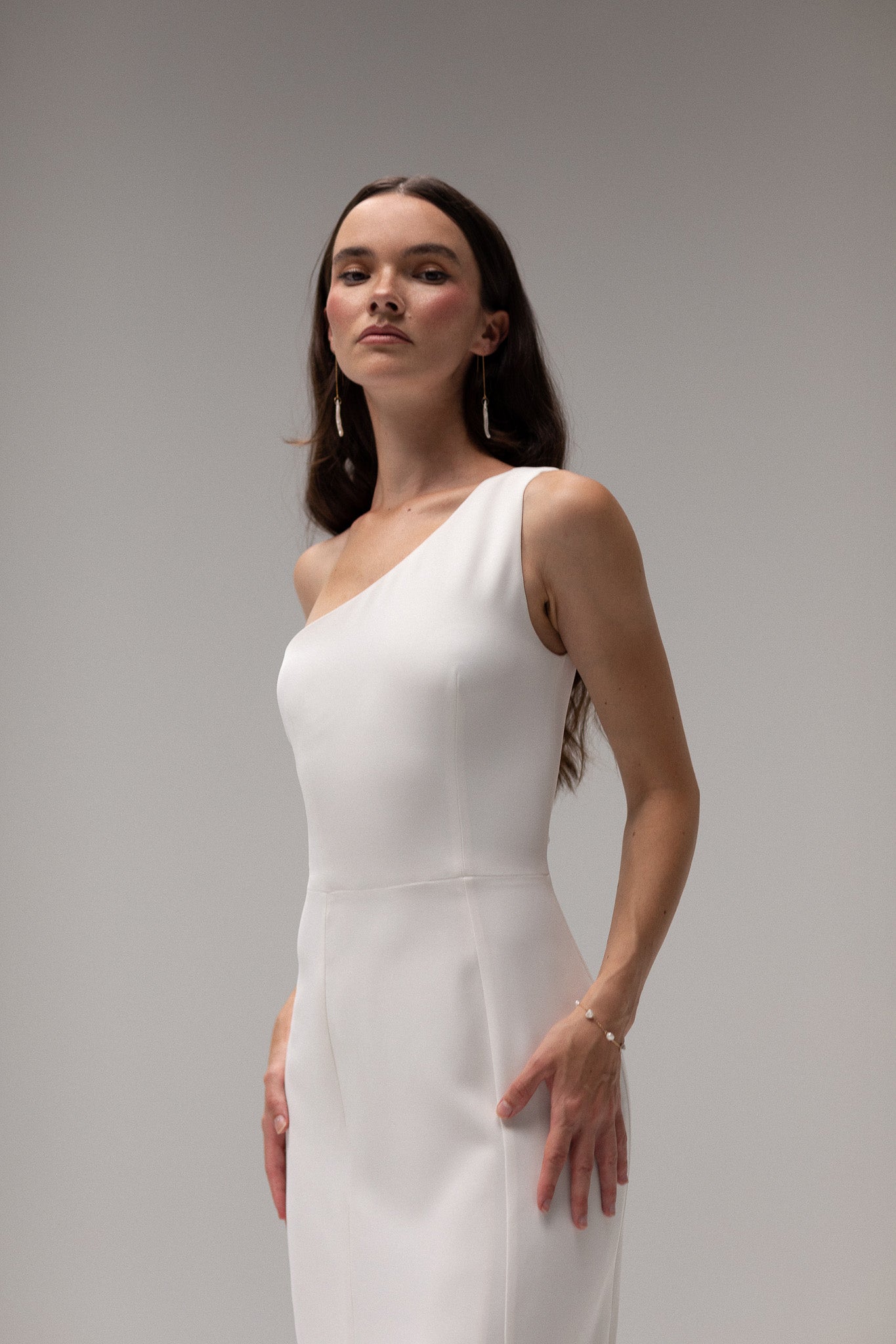 Close-up of crepe one shoulder gown from TEMPÊTE, highlighting its elegant crepe fabric and unique one-shoulder design.