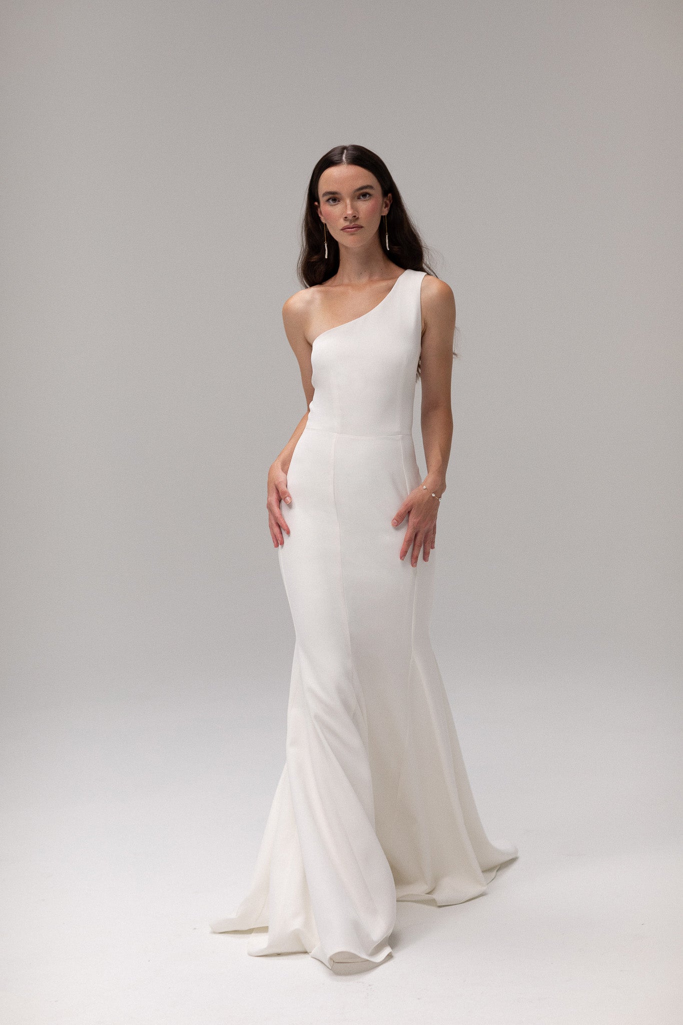 Close-up of crepe one shoulder gown from TEMPÊTE, highlighting its elegant crepe fabric and unique one-shoulder design.