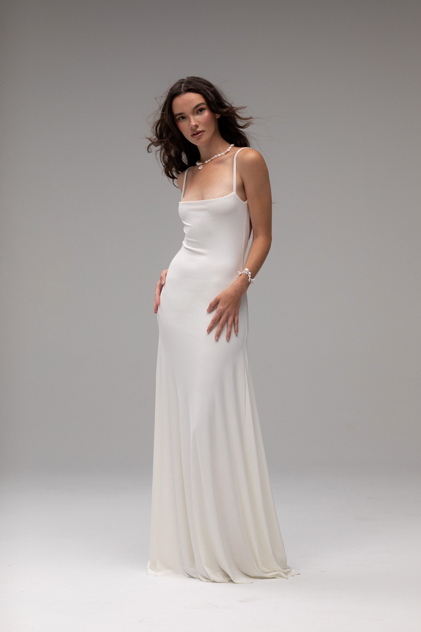 Bride in an open back jersey knit dress by TEMPÊTE, showcasing a flattering fit and modern design for a bold bridal look.