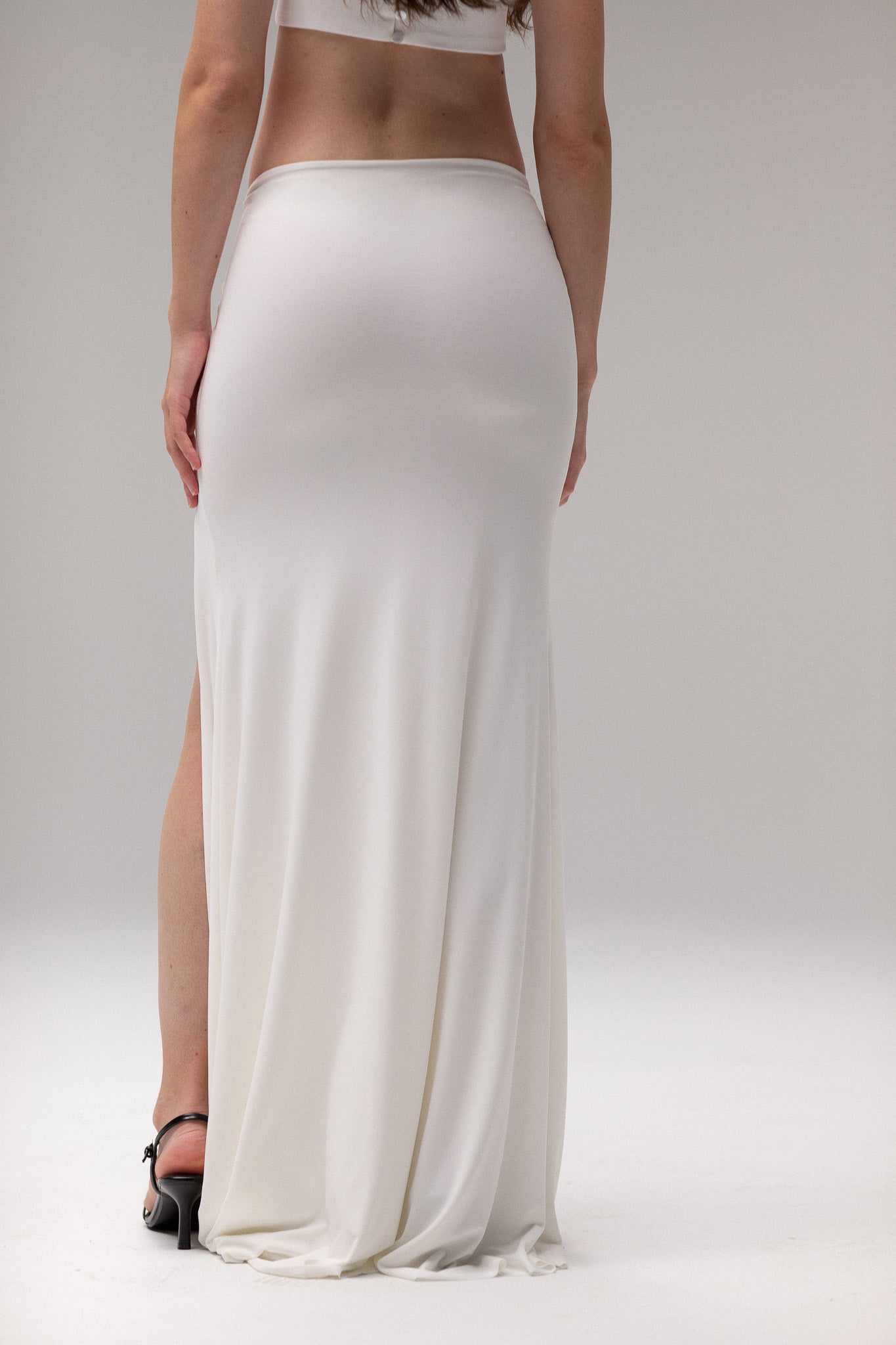 Bride in a draped knit slit skirt from TEMPÊTE, showcasing a fitted silhouette with a stylish slit, ideal for a bold and contemporary bridal outfit