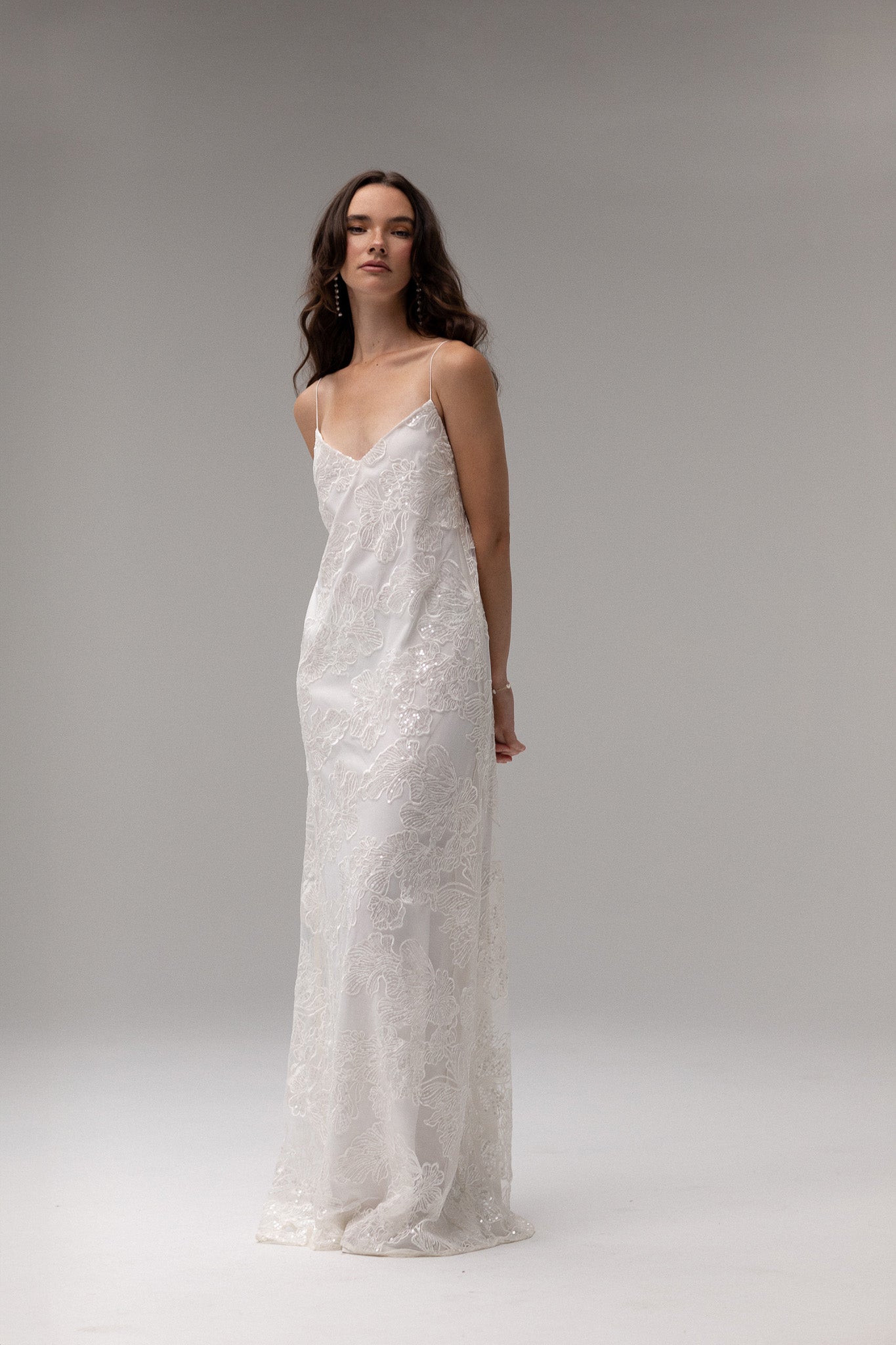 Detailed view of TEMPÊTE maxi bridal dress with delicate sequin lace, v-neck design, spaghetti straps, and an open back, ideal for a modern bridal look