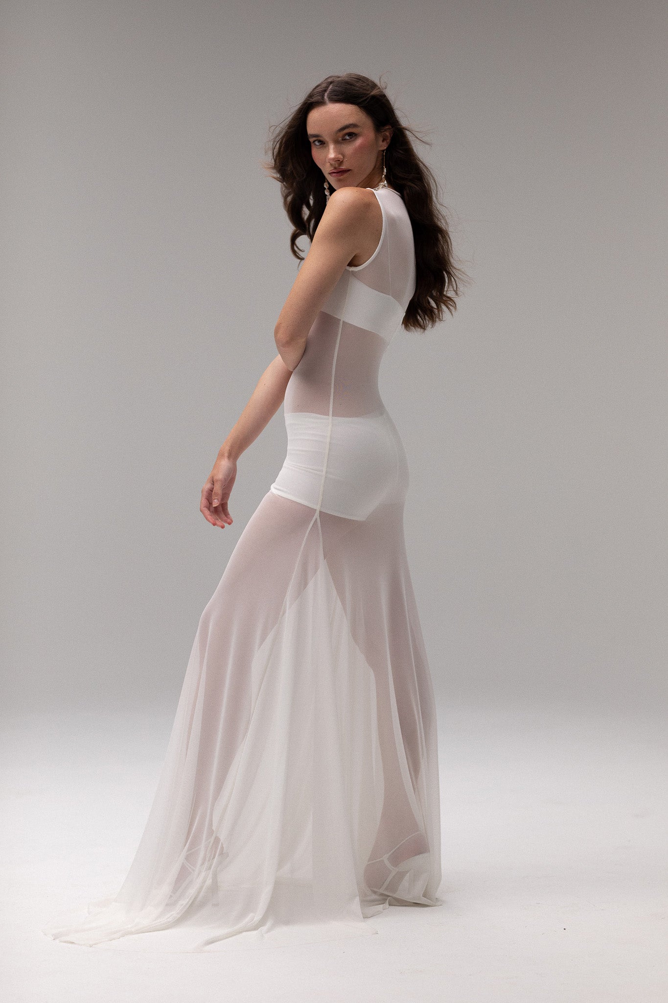 Detailed view of a sheer mesh dress from J'OSE Collection by TEMPÊTE with a high neck and flowing silhouette, ideal for layering in a modern bridal outfit