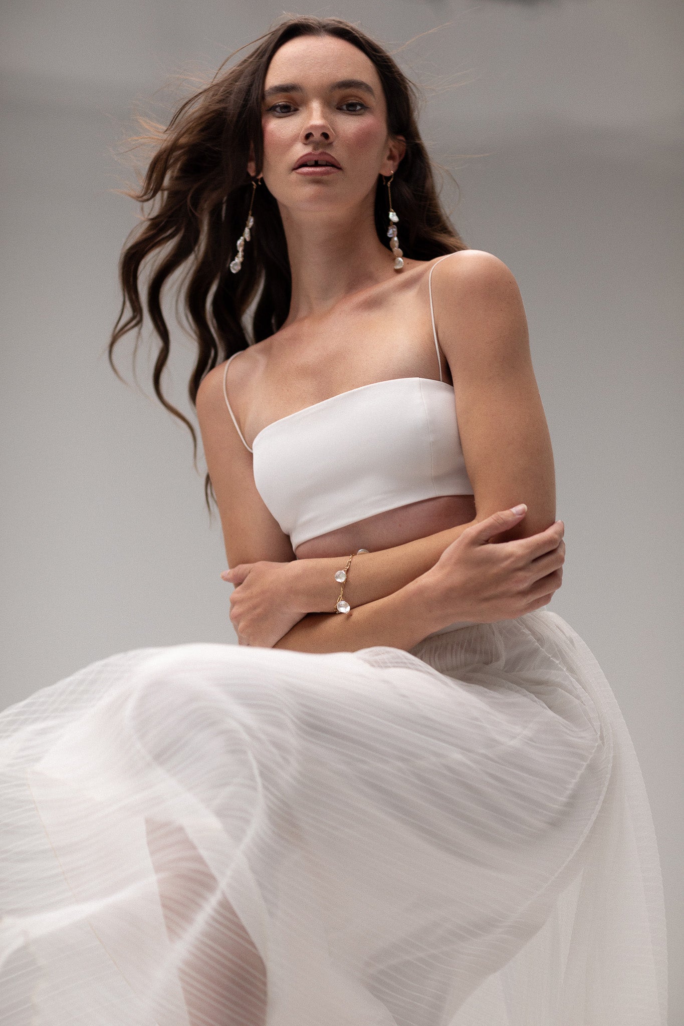 Model wearing a cropped tube top by TEMPÊTE, featuring a minimalist design with thin straps for a modern bridal style