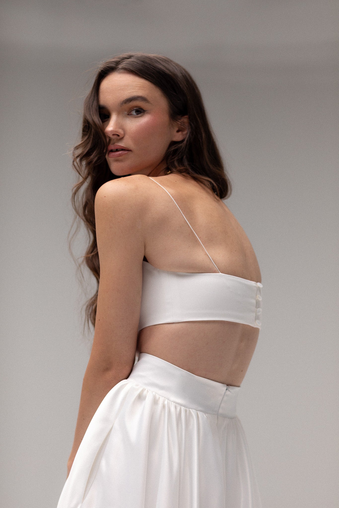 Model wearing a cropped tube top by TEMPÊTE, featuring a minimalist design with thin straps for a modern bridal style