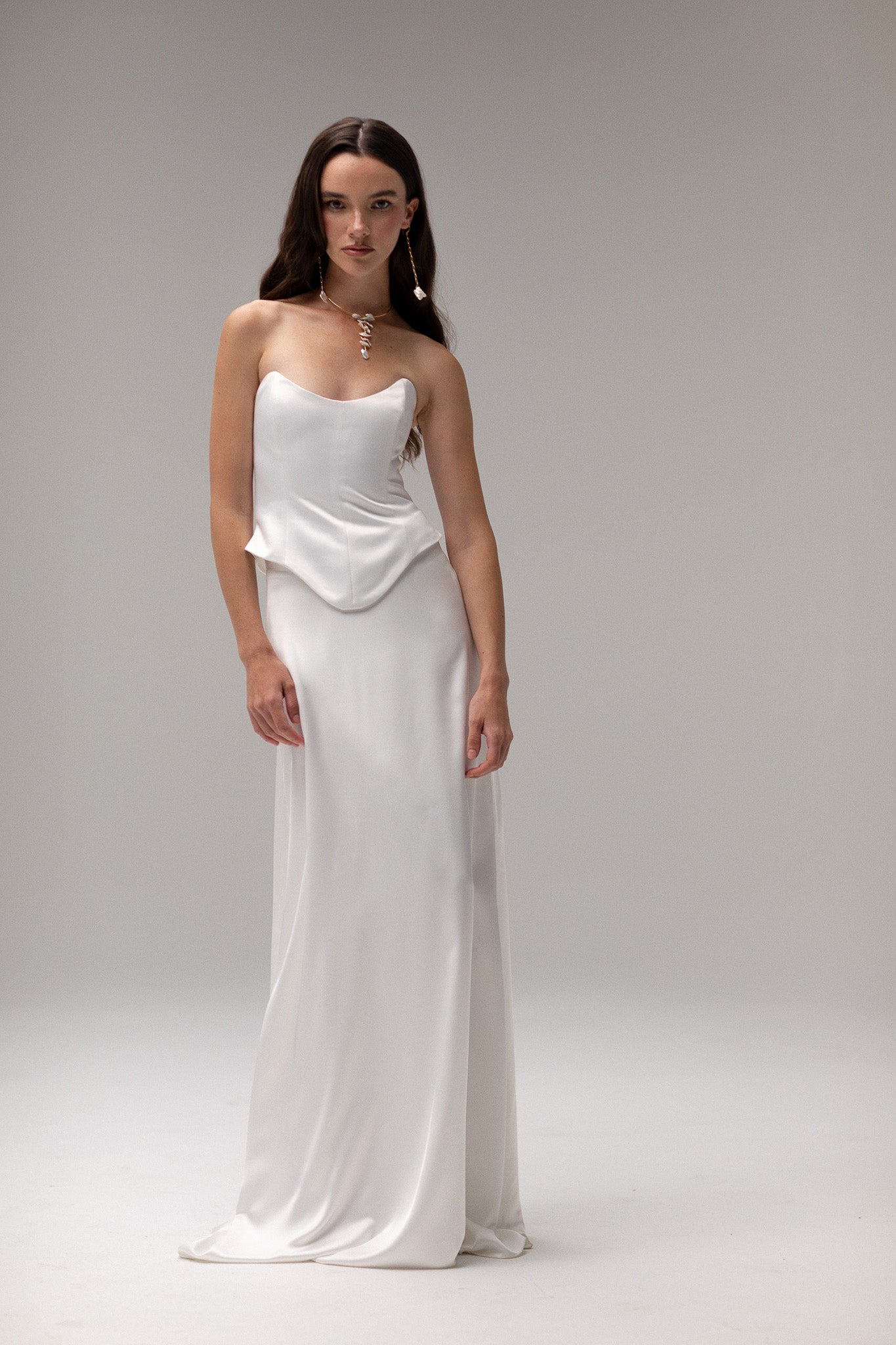 Model wearing a matte satin maxi skirt from the J'OSE Collection by TEMPÊTE, featuring a high-waisted design with a flowing silhouette, perfect for a refined bridal look.