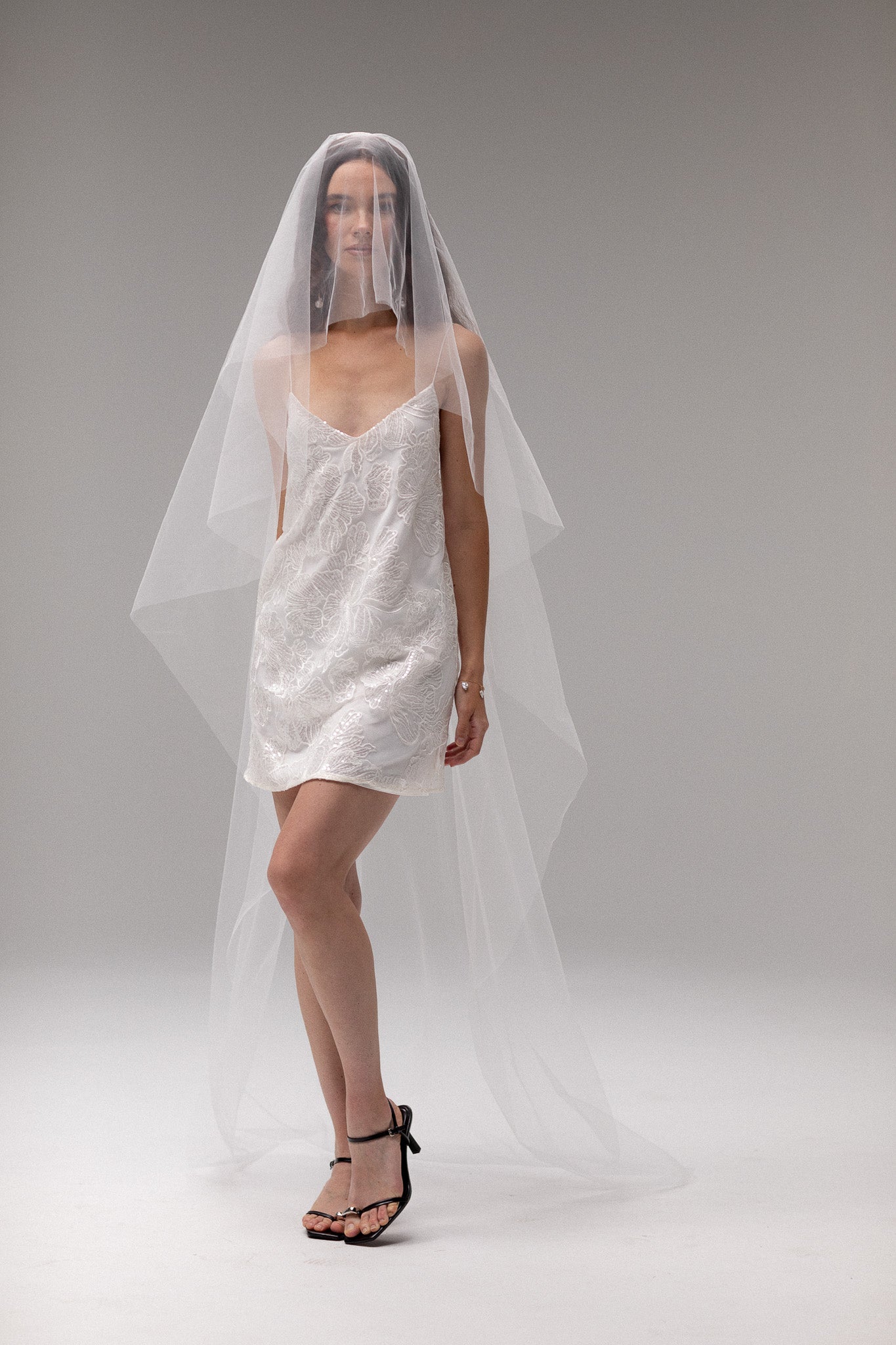 Bride in TEMPÊTE’s short blusher tulle veil, showcasing a minimal design that pairs beautifully with any bridal look.