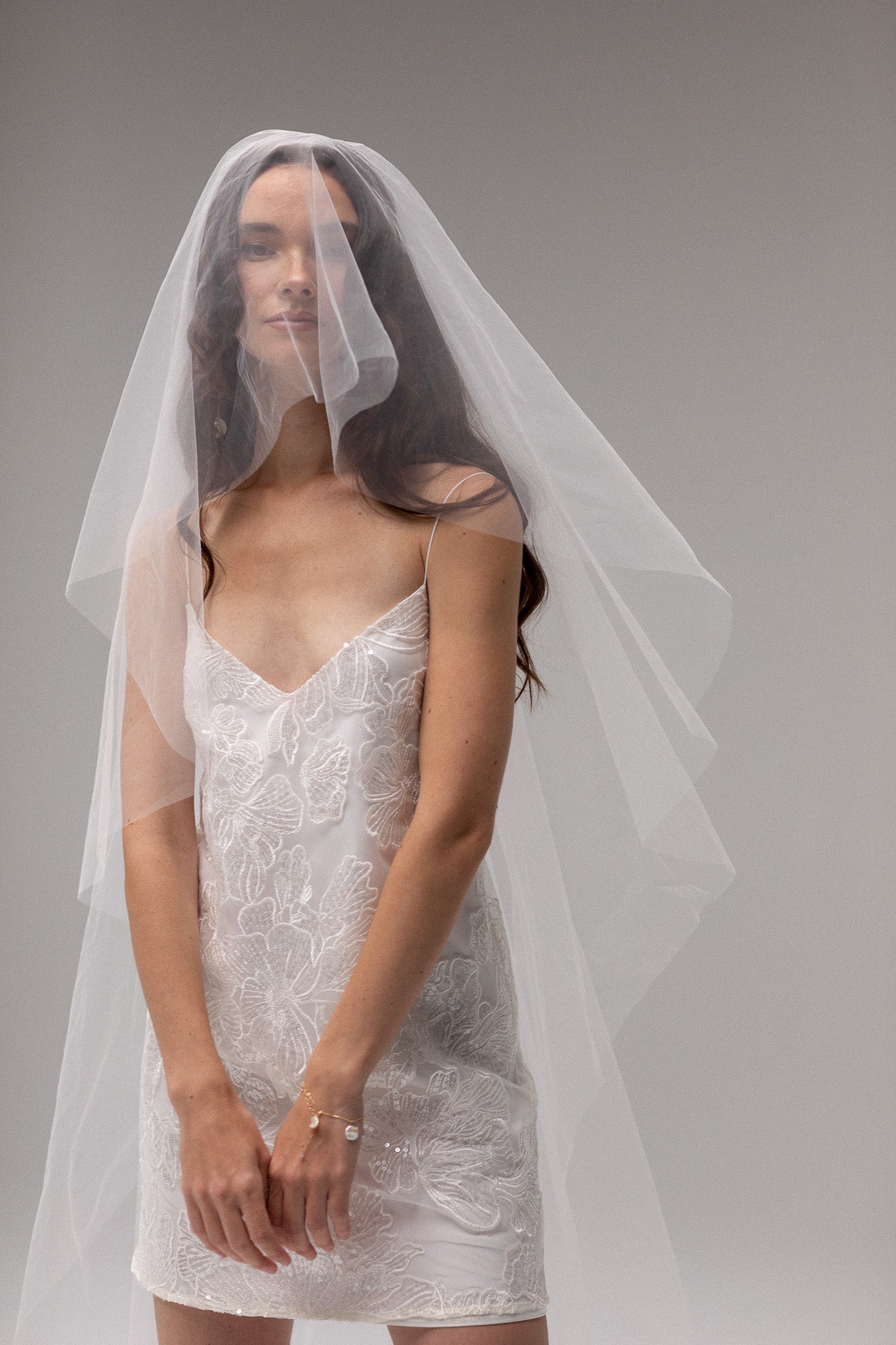 Bride in TEMPÊTE’s short blusher tulle veil, showcasing a minimal design that pairs beautifully with any bridal look.