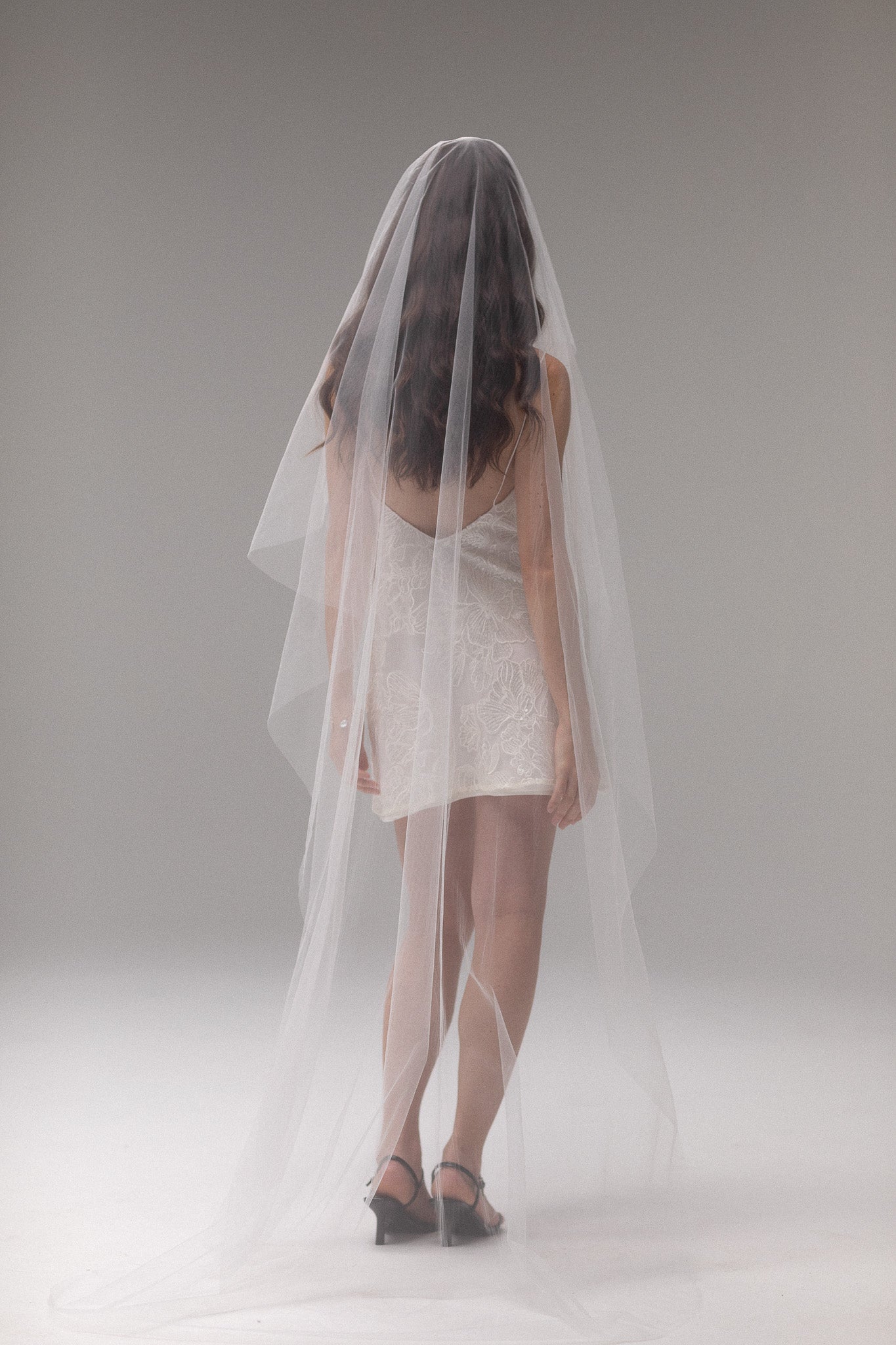 Bride in TEMPÊTE’s short blusher tulle veil, showcasing a minimal design that pairs beautifully with any bridal look.