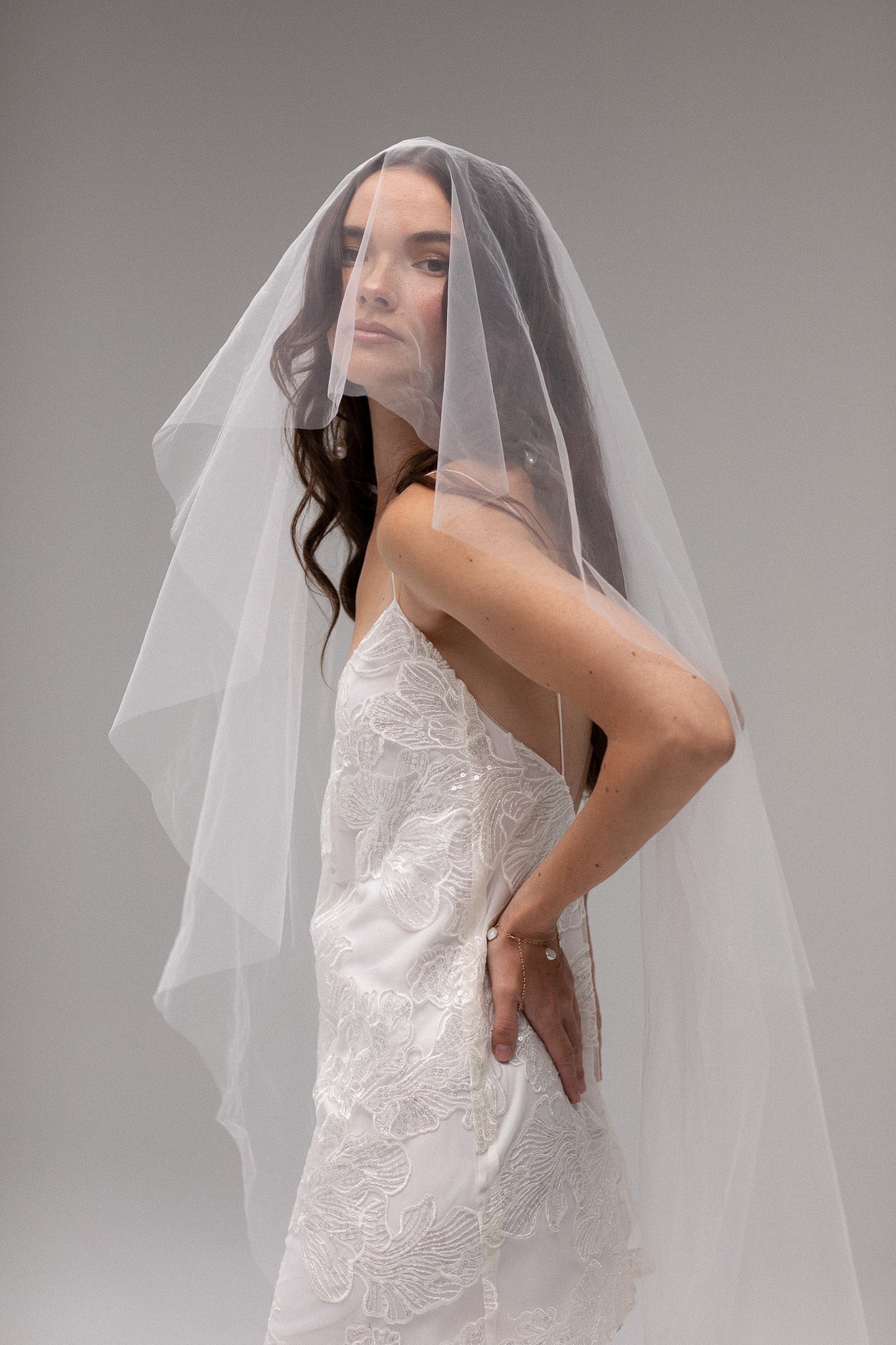 Bride in TEMPÊTE’s short blusher tulle veil, showcasing a minimal design that pairs beautifully with any bridal look.