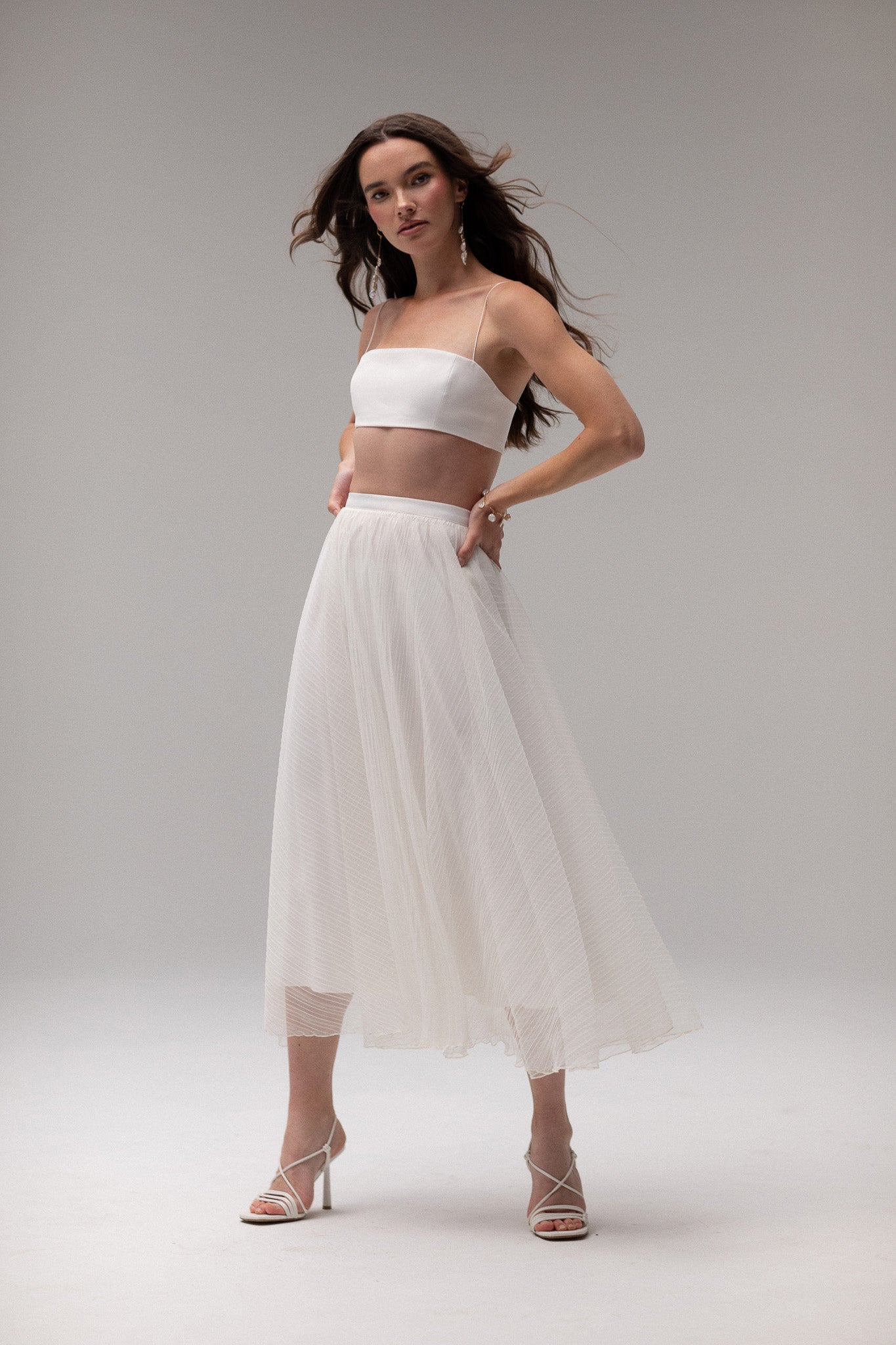 Model wearing a midi satin slip skirt by TEMPÊTE, featuring a smooth satin finish and elegant mid-length.