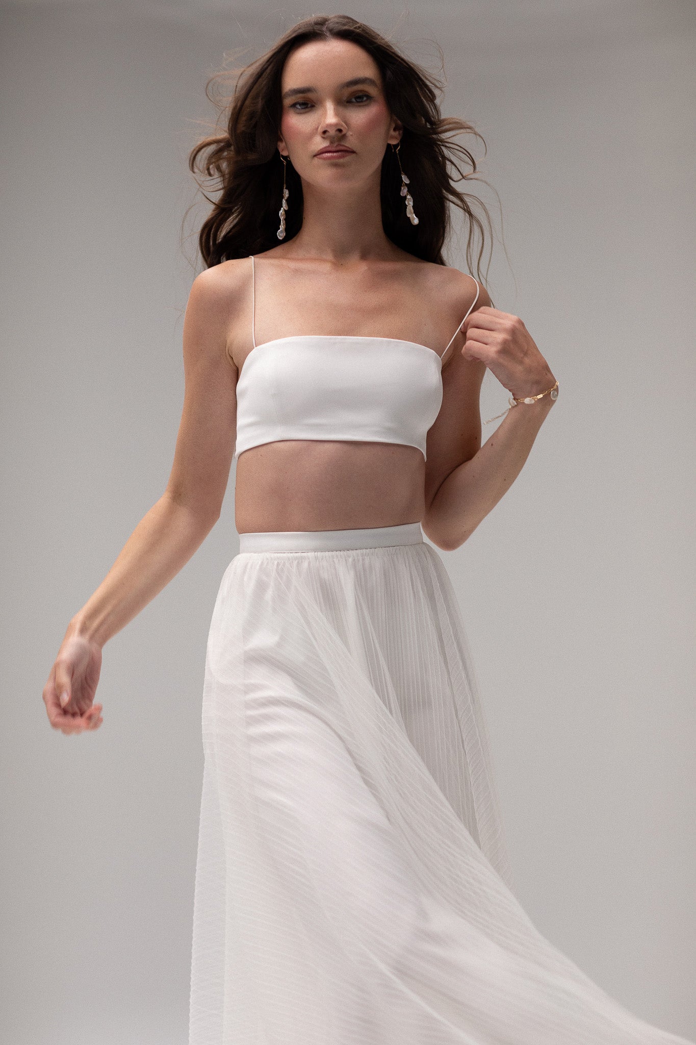 Model wearing a cropped tube top by TEMPÊTE, featuring a minimalist design with thin straps for a modern bridal style