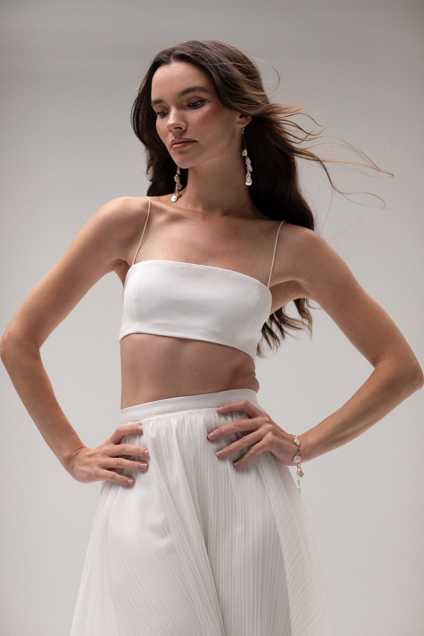 Model wearing a cropped tube top by TEMPÊTE, featuring a minimalist design with thin straps for a modern bridal style