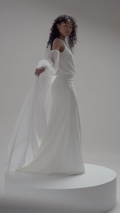 The Soleste Chiffon Veil by TEMPÊTE features a full-length chiffon train, finished with a sleek metal comb, offering a timeless and statement-making bridal look.