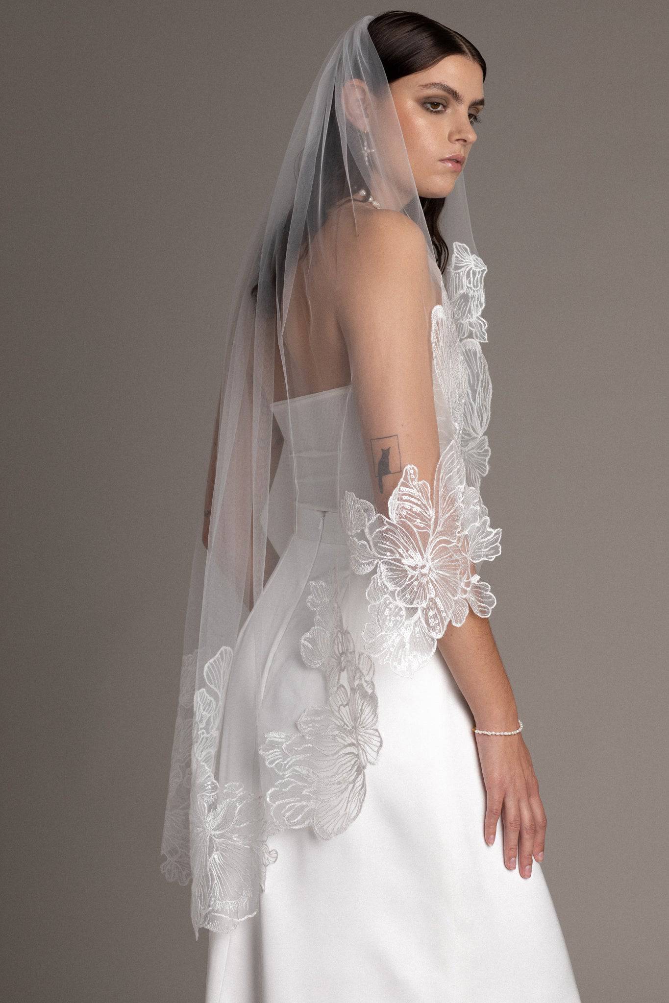 Back close up of French lace tulle veil by TEMPÊTE bridal brand with delicate floral sequin applique on the edges