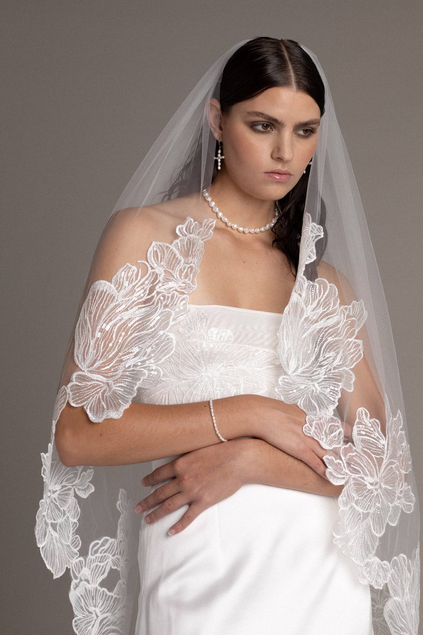 Close up of French lace tulle veil by TEMPÊTE bridal brand with delicate floral sequin applique on the edges