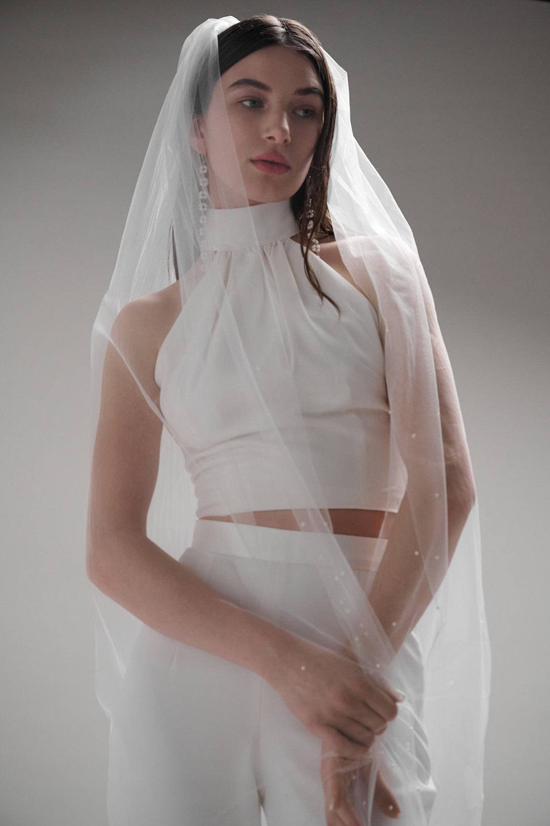 Acacia Pearl Veil by TEMPÊTE, crafted from soft, silky tulle with a delicate pearl trim along the edges, secured with a comb for easy placement.