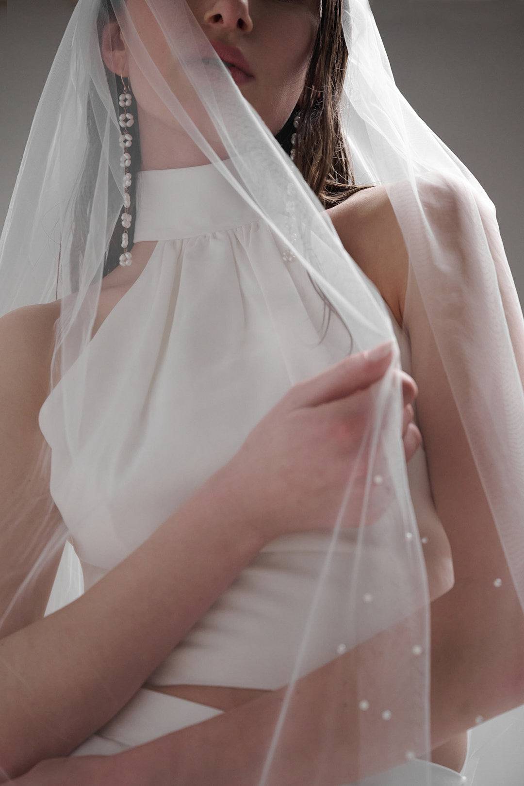 Acacia Pearl Veil by TEMPÊTE, crafted from soft, silky tulle with a delicate pearl trim along the edges, secured with a comb for easy placement.