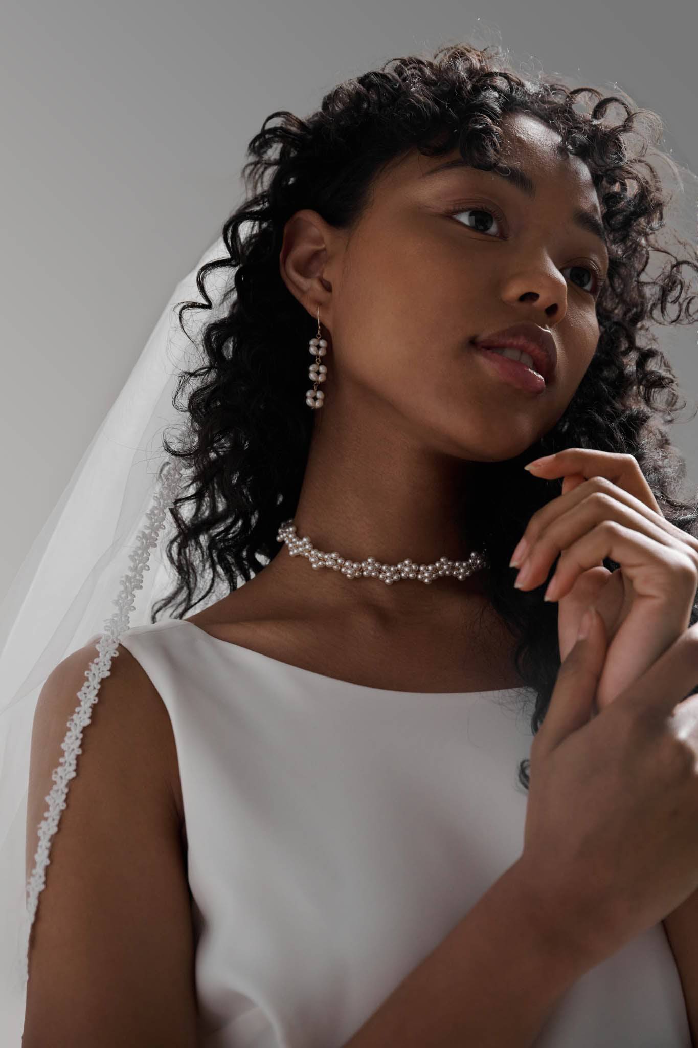 Close up of Daisy Floral Lace Veil by TEMPÊTE, featuring a soft tulle base and delicate floral lace trim