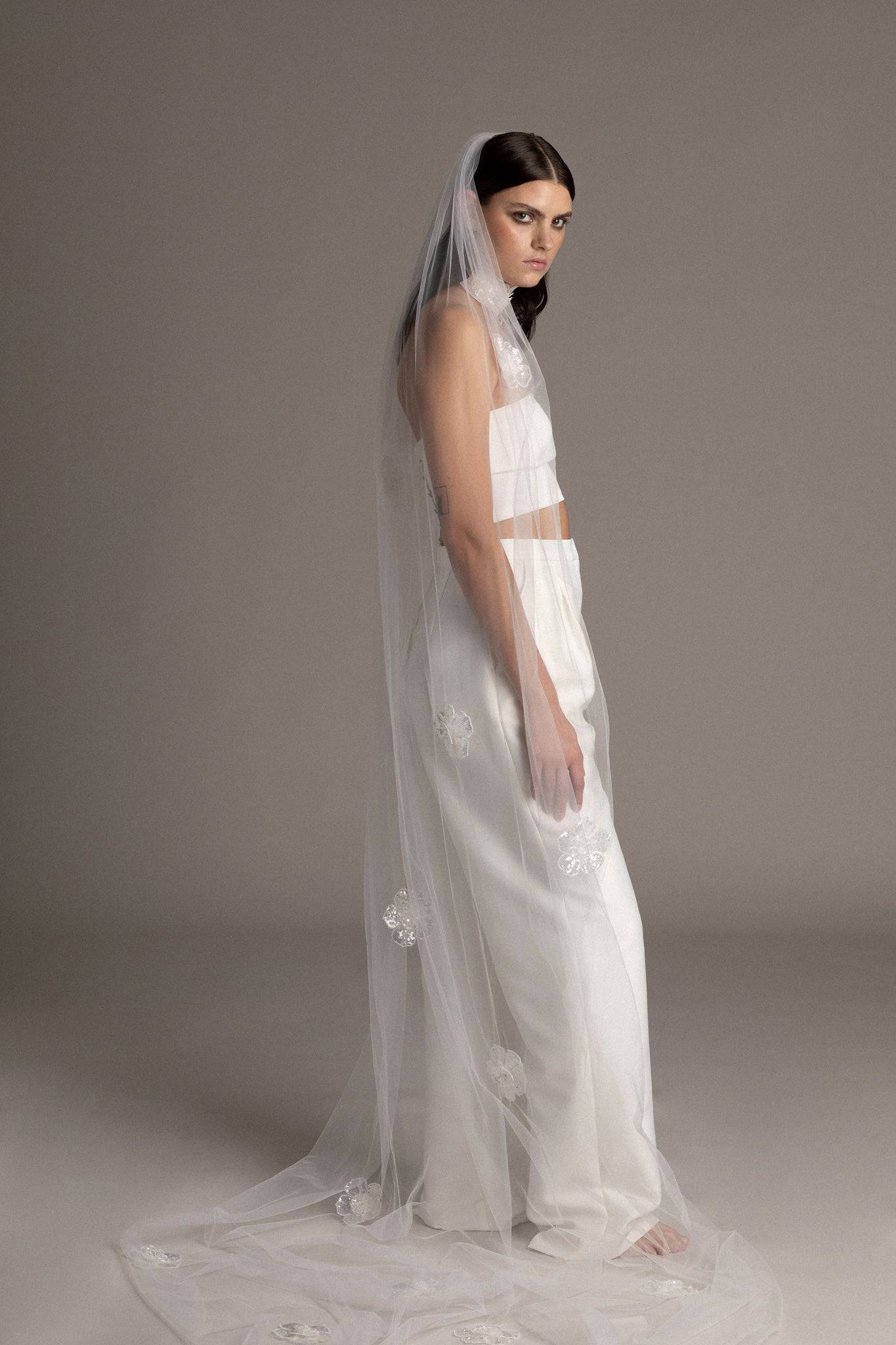 Side view of a bride wearing the Sequin Flower Tulle Veil by TEMPÊTE, featuring delicate sequin flowers that span the length of the veil