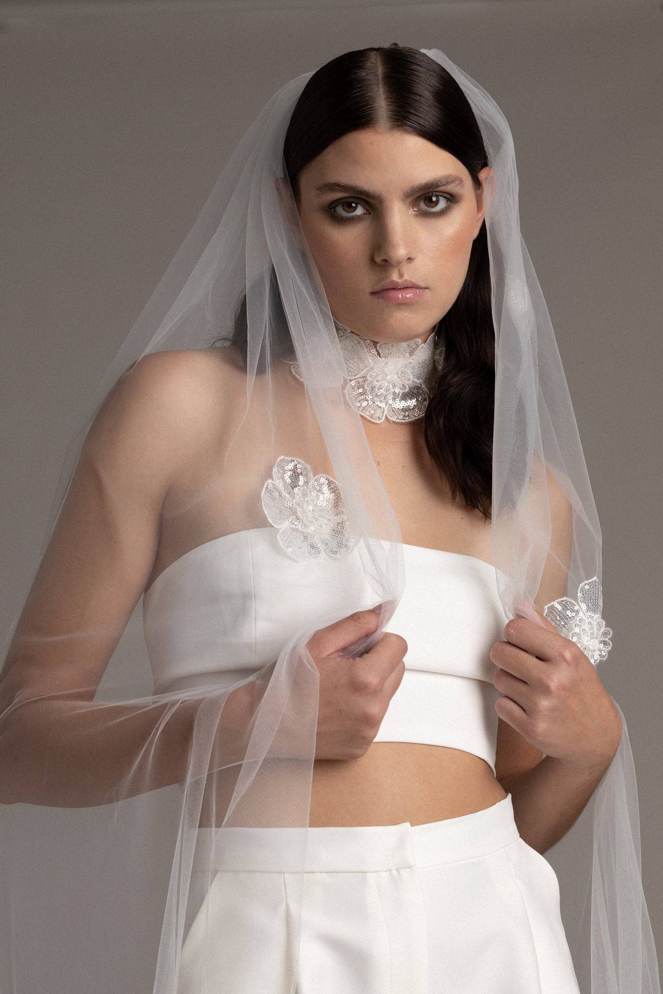 Close up of a bride wearing the Sequin Flower Tulle Veil by TEMPÊTE, featuring delicate sequin flowers that span the length of the veil