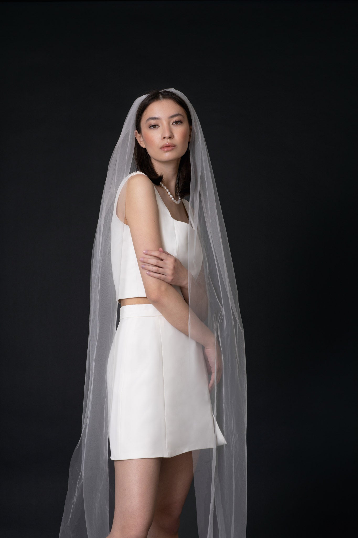 Best-selling Eloise Minimalist Tulle Veil by TEMPÊTE, crafted from fine ivory tulle and featuring a delicate golden comb for a classic, elegant bridal look